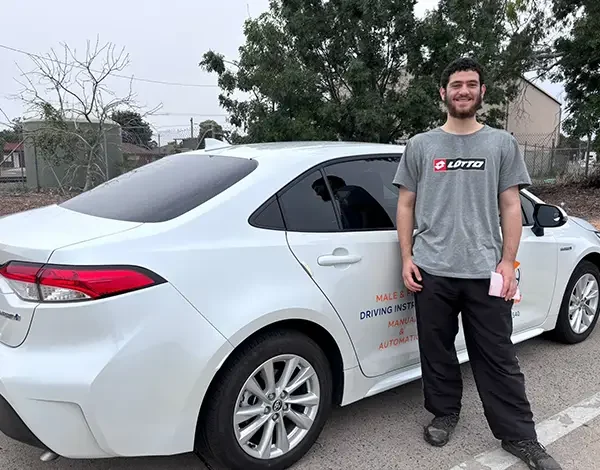 Local student standing beside a GV Driving School training vehicle