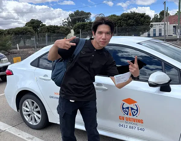 Automatic Driving Lessons 14 Successful test candidate beside a GV Driving School Toyota Corolla