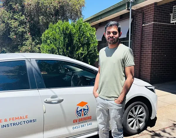 Learner driver celebrating a milestone beside an automatic training car