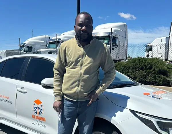 New P-plater standing beside a Toyota Corolla learner driver vehicle