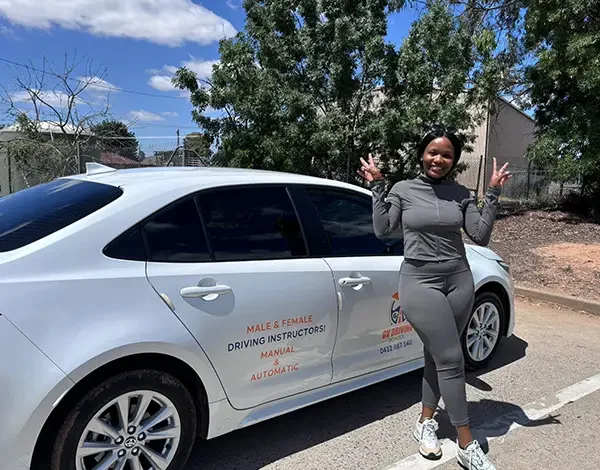 Driving test result celebration beside a learner driver car